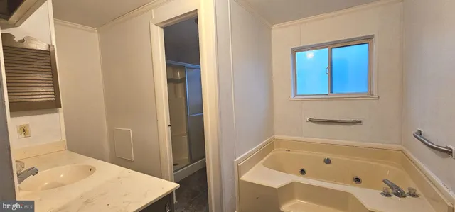 a bathroom with a tub a sink and a window
