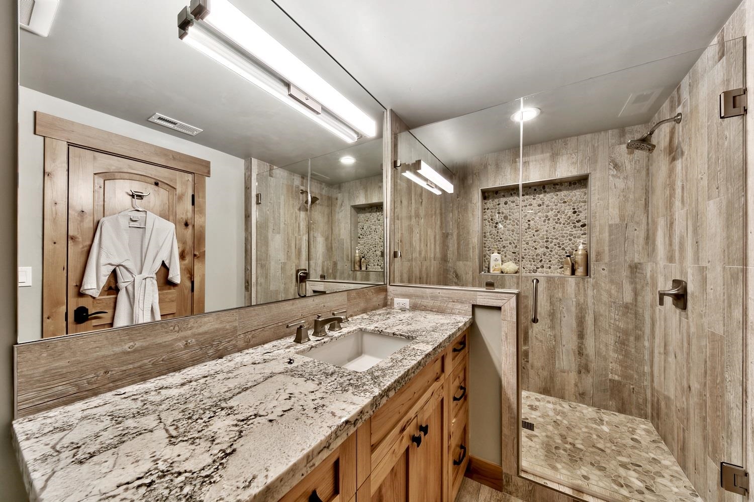 164 Basque Drive Truckee, CA 96161 - Photo 18 of 21 a bathroom with a granite countertop sink mirror and shower