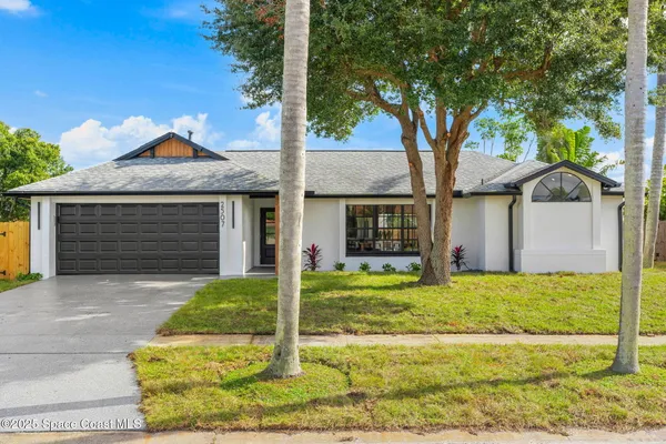 a view of a house with backyard and tree