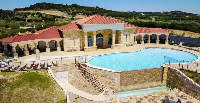a view of a house with pool and chairs