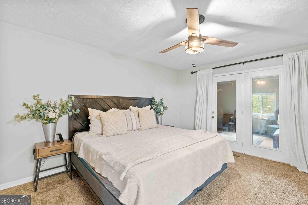 1881 Timberlane Road Milledgeville, GA 31061 - Photo 9 of 28 a bedroom with a large bed and a chandelier fan