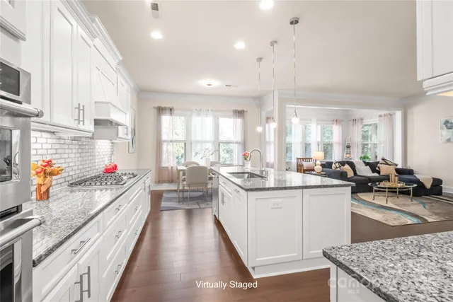 a kitchen with stainless steel appliances granite countertop a sink stove and cabinets
