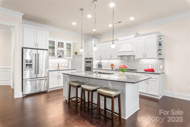 a kitchen with granite countertop a table chairs microwave and cabinets
