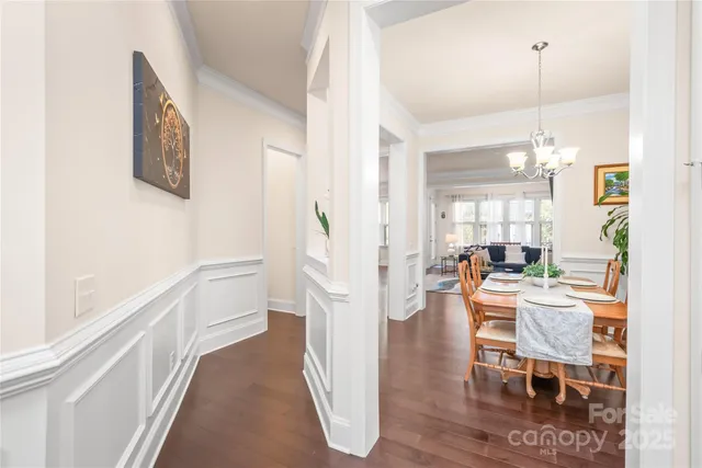 a dining room with furniture potted plants and wooden floor