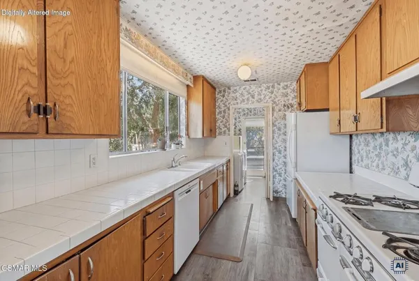a kitchen with stainless steel appliances granite countertop a stove a sink and a refrigerator