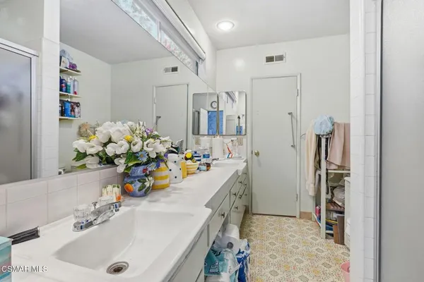 a bathroom with a sink a faucet a mirror and shower