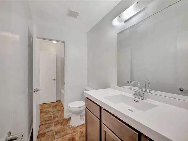 a bathroom with a sink a toilet and a large mirror