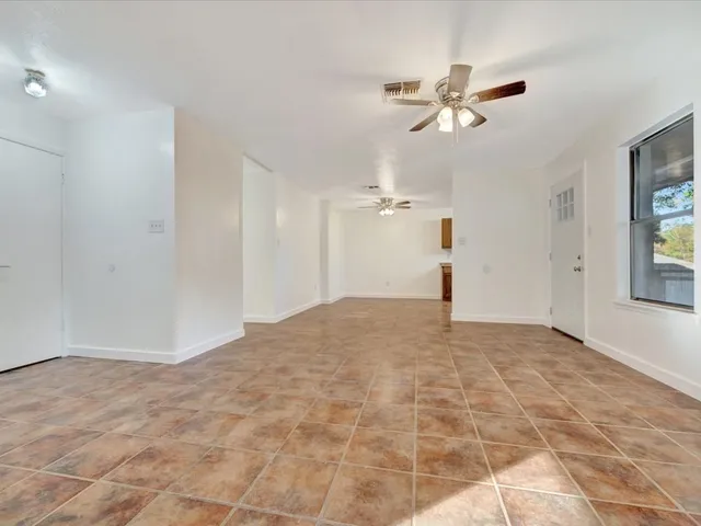a view of a livingroom with a ceiling fan and window