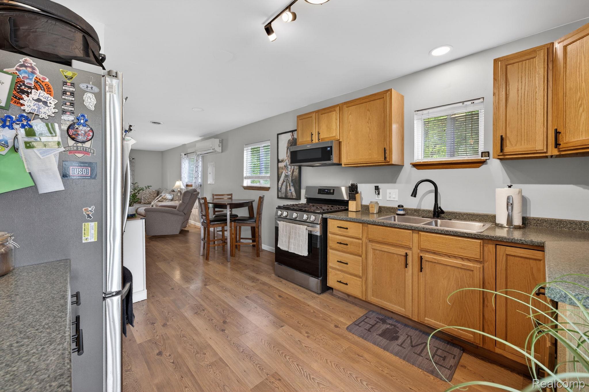 6354 Lapeer Road Burton, MI 48509 - Photo 24 of 44 Kitchen with stainless steel appliances, plenty of natural light, light wood-style flooring, and dark stone countertops