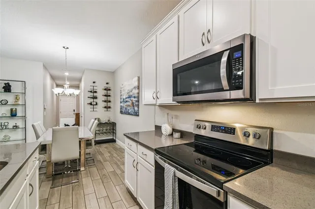 a kitchen with stainless steel appliances a stove a microwave cabinets and a wooden floor