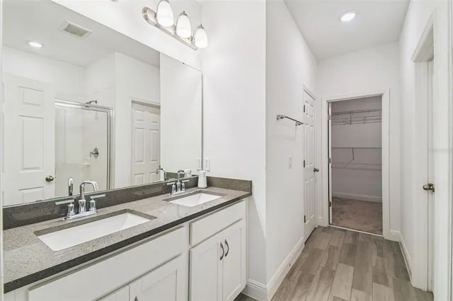 a bathroom with a sink double vanity granite tub and shower