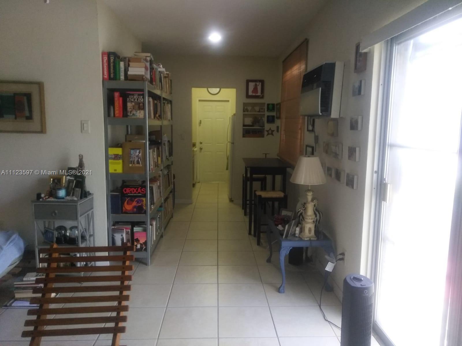 7720 Harding Avenue, Unit 1 Miami Beach, FL 33141 - Photo 4 of 7 a hallway with wine glasses in a room