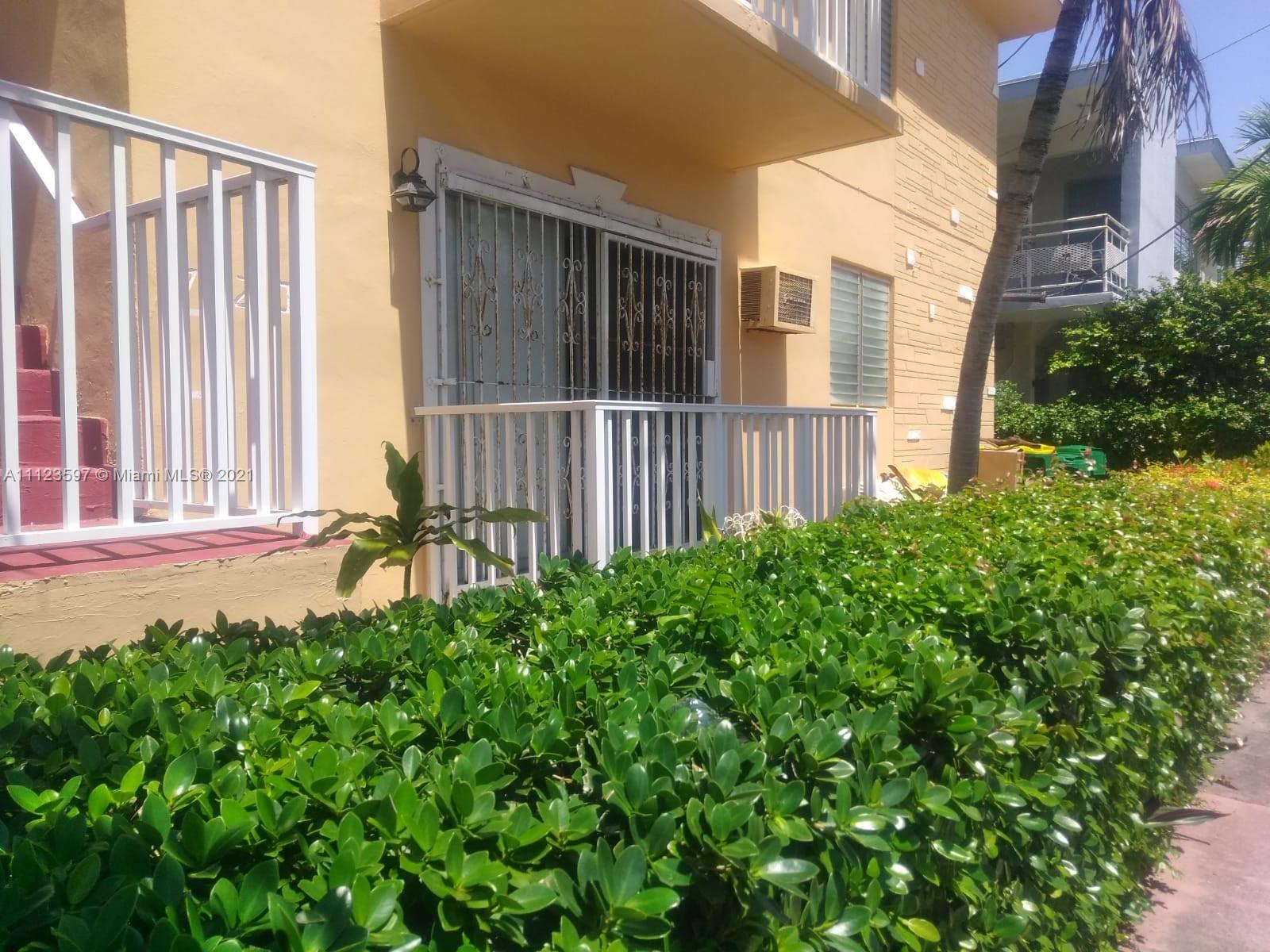7720 Harding Avenue, Unit 1 Miami Beach, FL 33141 - Photo 6 of 7 a view of a house with a small yard and wooden floor and fence