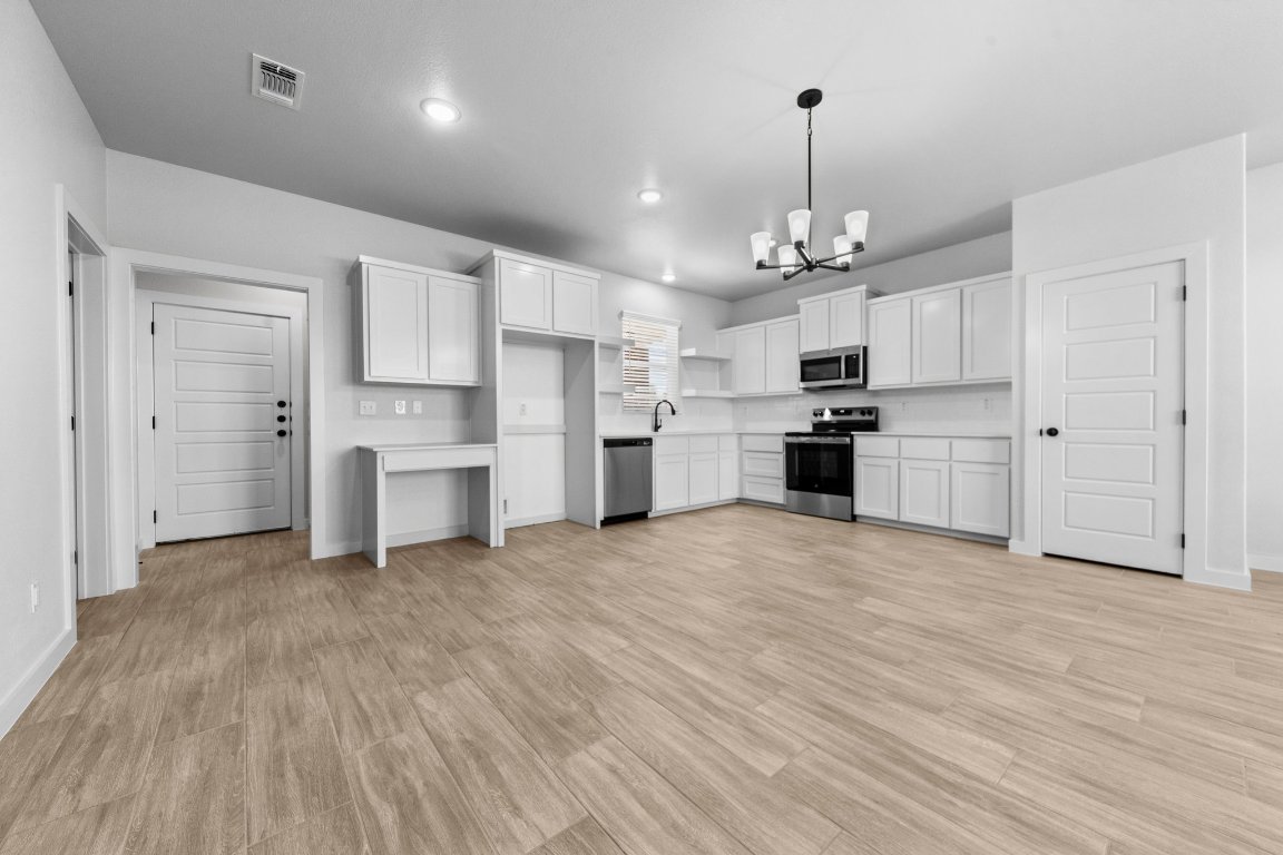 a view of kitchen with refrigerator and cabinets
