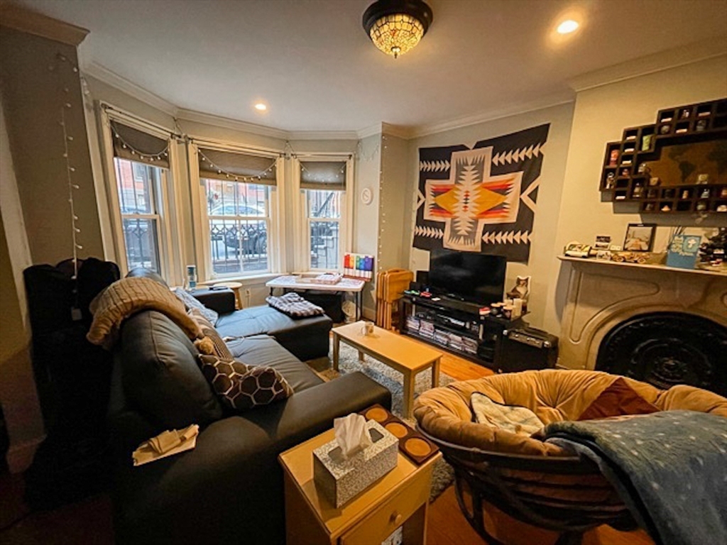57 Dwight Street, Unit G Boston, MA 02118 - Photo 27 of 28 a living room with furniture a flat screen tv and a fireplace