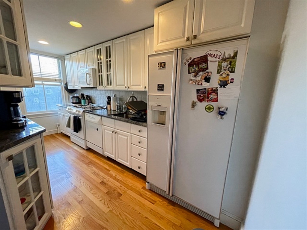 57 Dwight Street, Unit G Boston, MA 02118 - Photo 4 of 28 a kitchen with stainless steel appliances a refrigerator a sink and wooden cabinets
