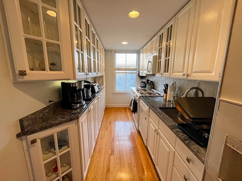 57 Dwight Street, Unit G Boston, MA 02118 - Photo 5 of 28 a kitchen with granite countertop a stove sink and cabinets