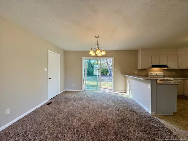 a view of a kitchen with stove cabinets and a wooden floor