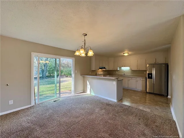 a view of large kitchen with refrigerator and window