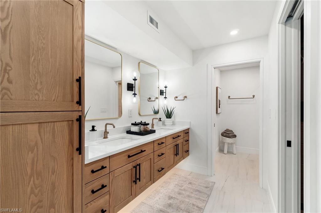 6804 Sand Pointe Circle Naples, FL 34108 - Photo 28 of 49 Exquisite spa bath. Quartz counter, rose-godl fixtures, under-cabinet lighting, storage mirrors