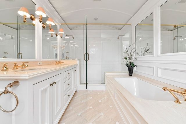 a spacious bathroom with a tub sink and mirror