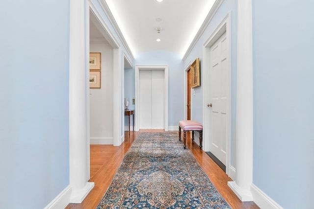 a view of a hallway with wooden floor and staircase
