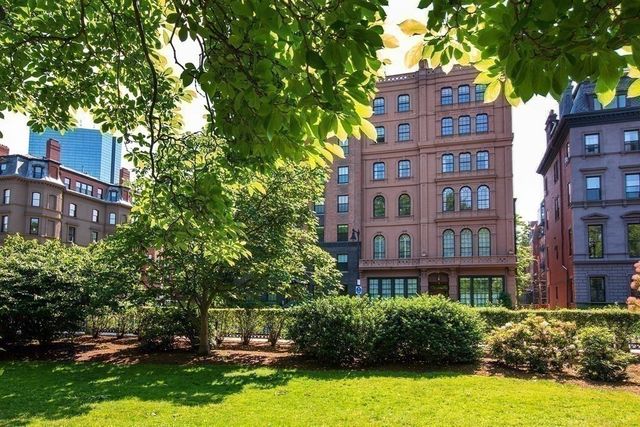 a view of a tall building and large trees