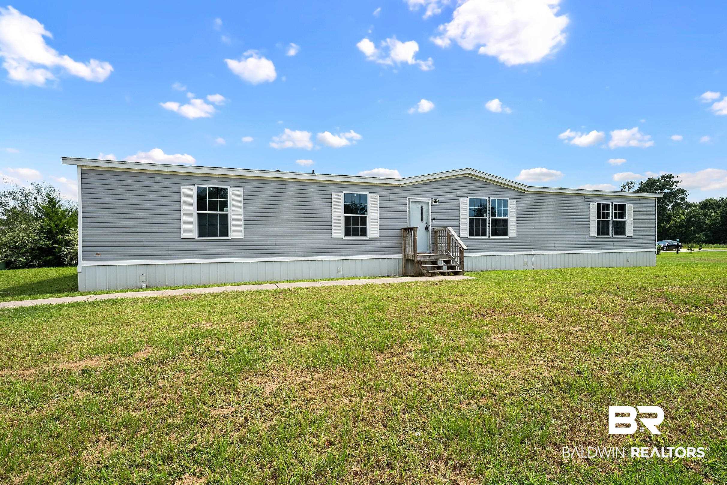 21601 Westside Loop Silverhill, AL 36576 - Photo 7 of 42 Gray vinyl siding exterior with white window shutters and trim
