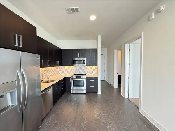 a kitchen with stainless steel appliances a refrigerator and a stove top oven