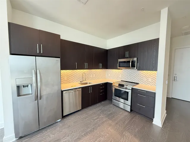 a large kitchen with stainless steel appliances granite countertop a refrigerator and a stove