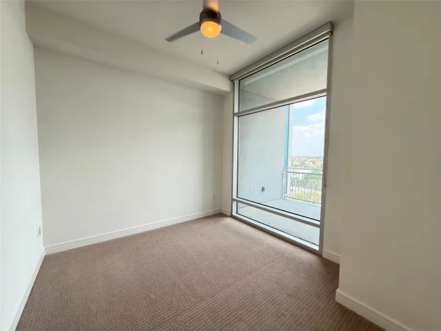 an empty room with a ceiling fan and a window