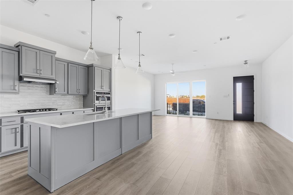 1203 Doris May Drive Allen, TX 75013 - Photo 19 of 35 a kitchen with stainless steel appliances granite countertop a stove a sink dishwasher and a refrigerator with wooden floor