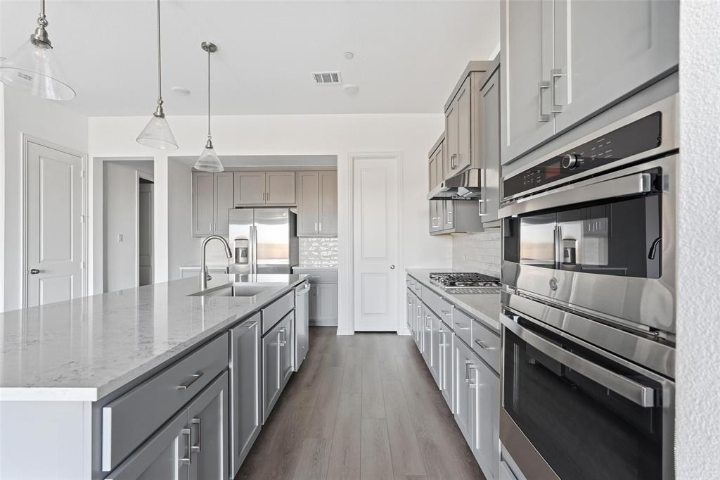 1203 Doris May Drive Allen, TX 75013 - Photo 23 of 35 a kitchen with stainless steel appliances granite countertop a stove and a sink