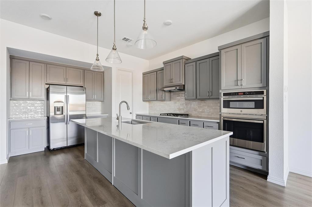 1203 Doris May Drive Allen, TX 75013 - Photo 26 of 35 a kitchen with stainless steel appliances granite countertop a sink stove and refrigerator
