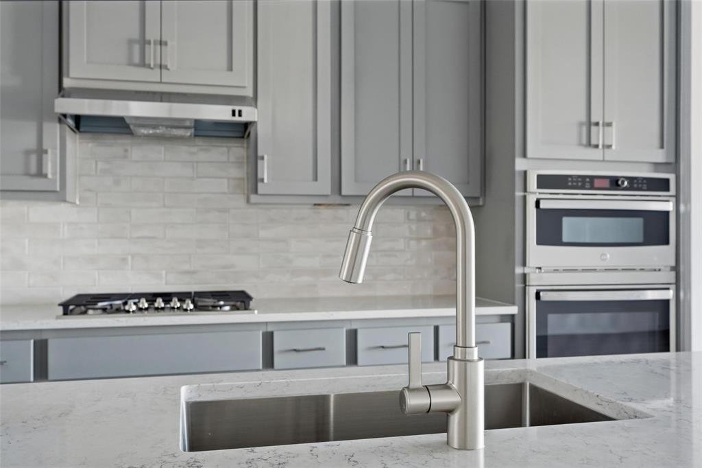 1203 Doris May Drive Allen, TX 75013 - Photo 27 of 35 a kitchen with granite countertop a stove and a sink