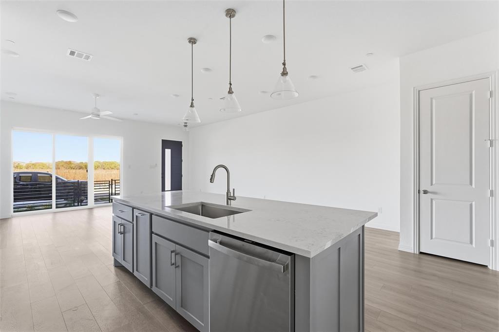 1203 Doris May Drive Allen, TX 75013 - Photo 28 of 35 a kitchen with stainless steel appliances granite countertop a sink a oven a dining table and chairs with wooden floor