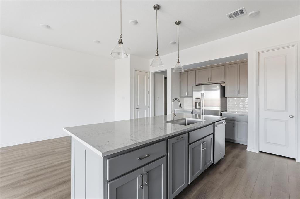 1203 Doris May Drive Allen, TX 75013 - Photo 29 of 35 a kitchen with a sink a counter space and wooden floor