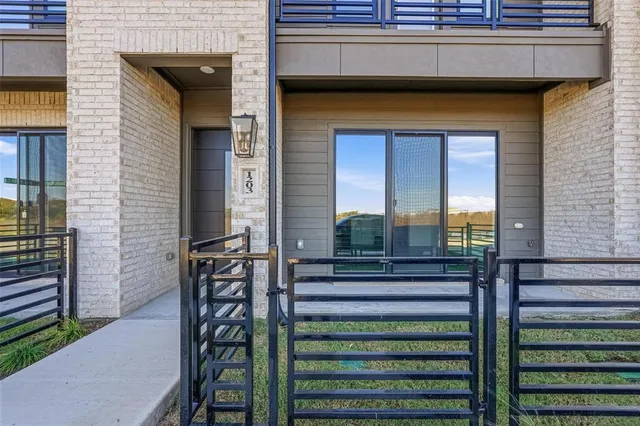 a view of a brick house with a small table and chairs