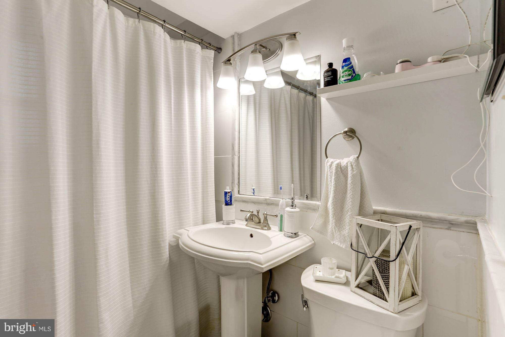 2604 Tunlaw Road Northwest, Unit 2 Washington, DC 20007 - Photo 18 of 25 a bathroom with a sink and mirror with bathtub