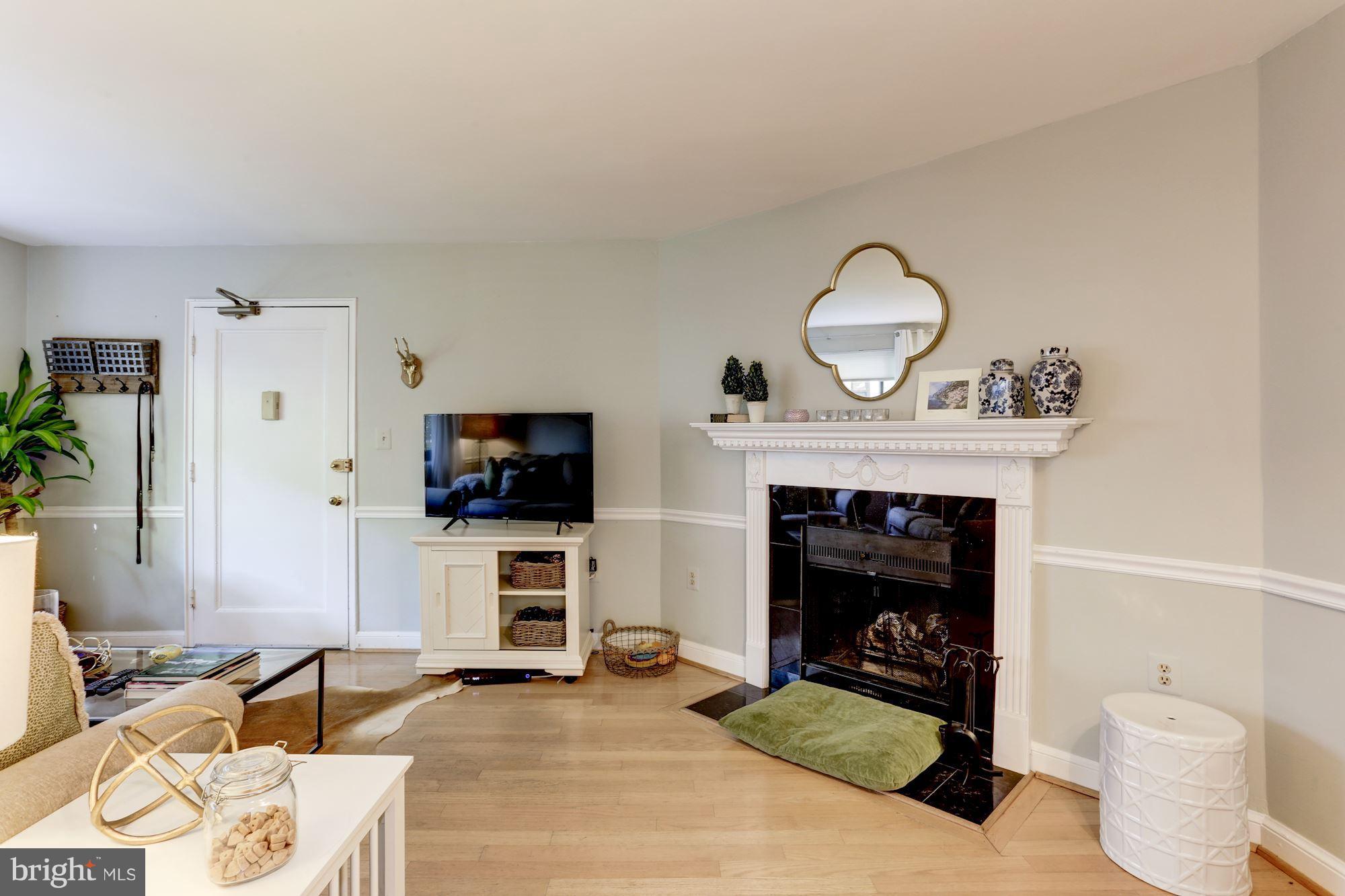2604 Tunlaw Road Northwest, Unit 2 Washington, DC 20007 - Photo 5 of 25 a living room with furniture a fireplace and flat screen tv