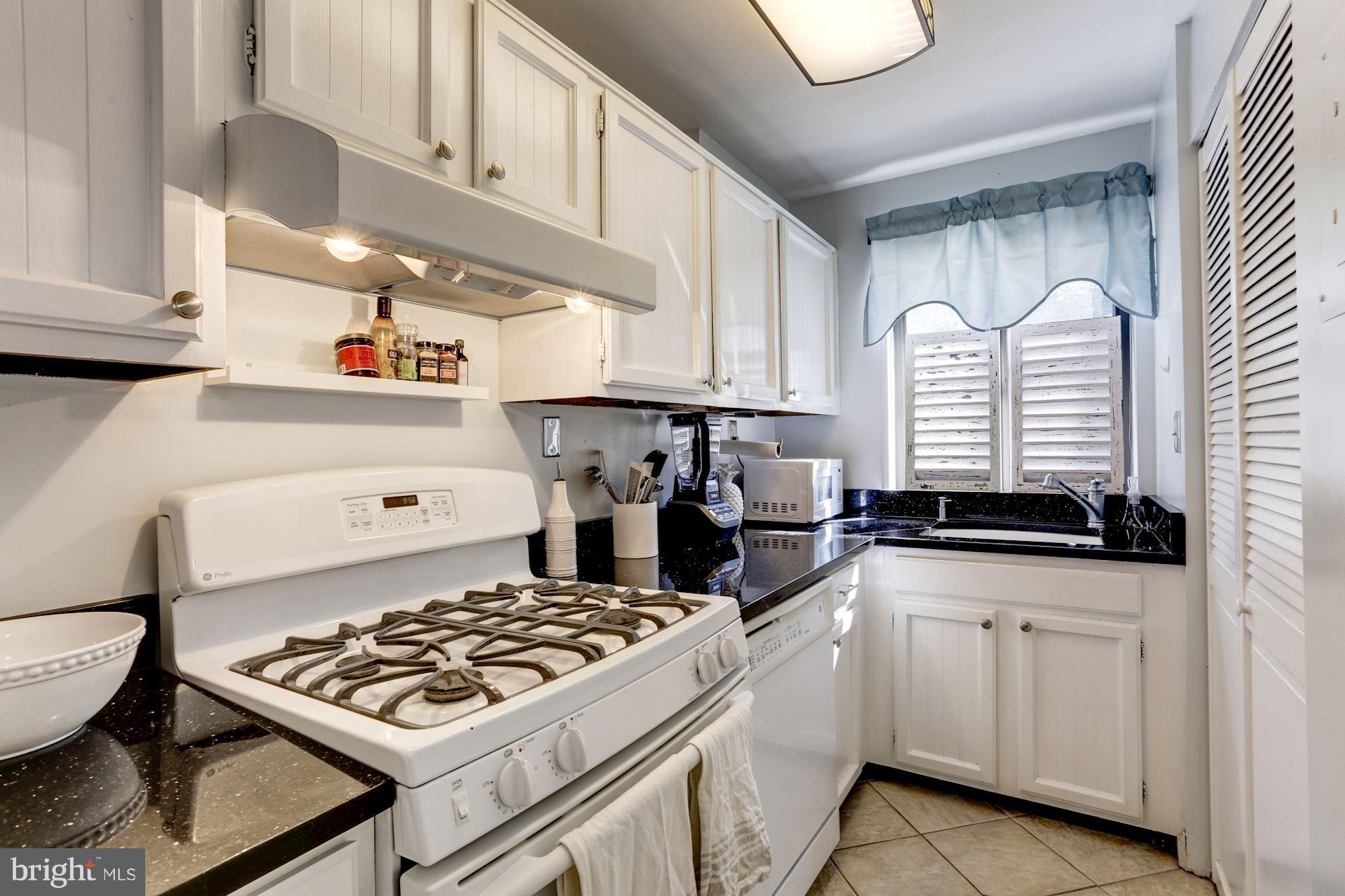 2604 Tunlaw Road Northwest, Unit 2 Washington, DC 20007 - Photo 10 of 25 a kitchen with white cabinets and appliances