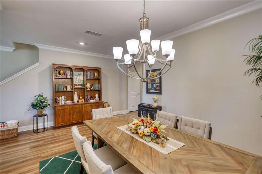 479 Glenmont Road Grayson, GA 30017 - Photo 17 of 58 a view of a dining room with furniture a chandelier and wooden floor
