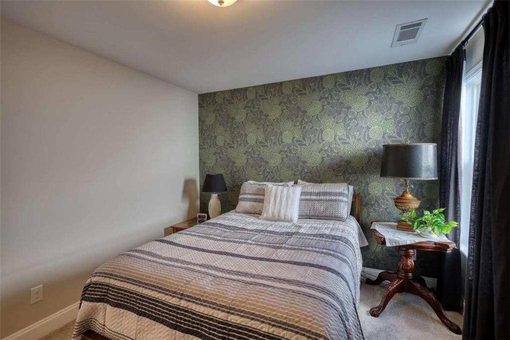 479 Glenmont Road Grayson, GA 30017 - Photo 40 of 58 a bedroom with a bed and a potted plant