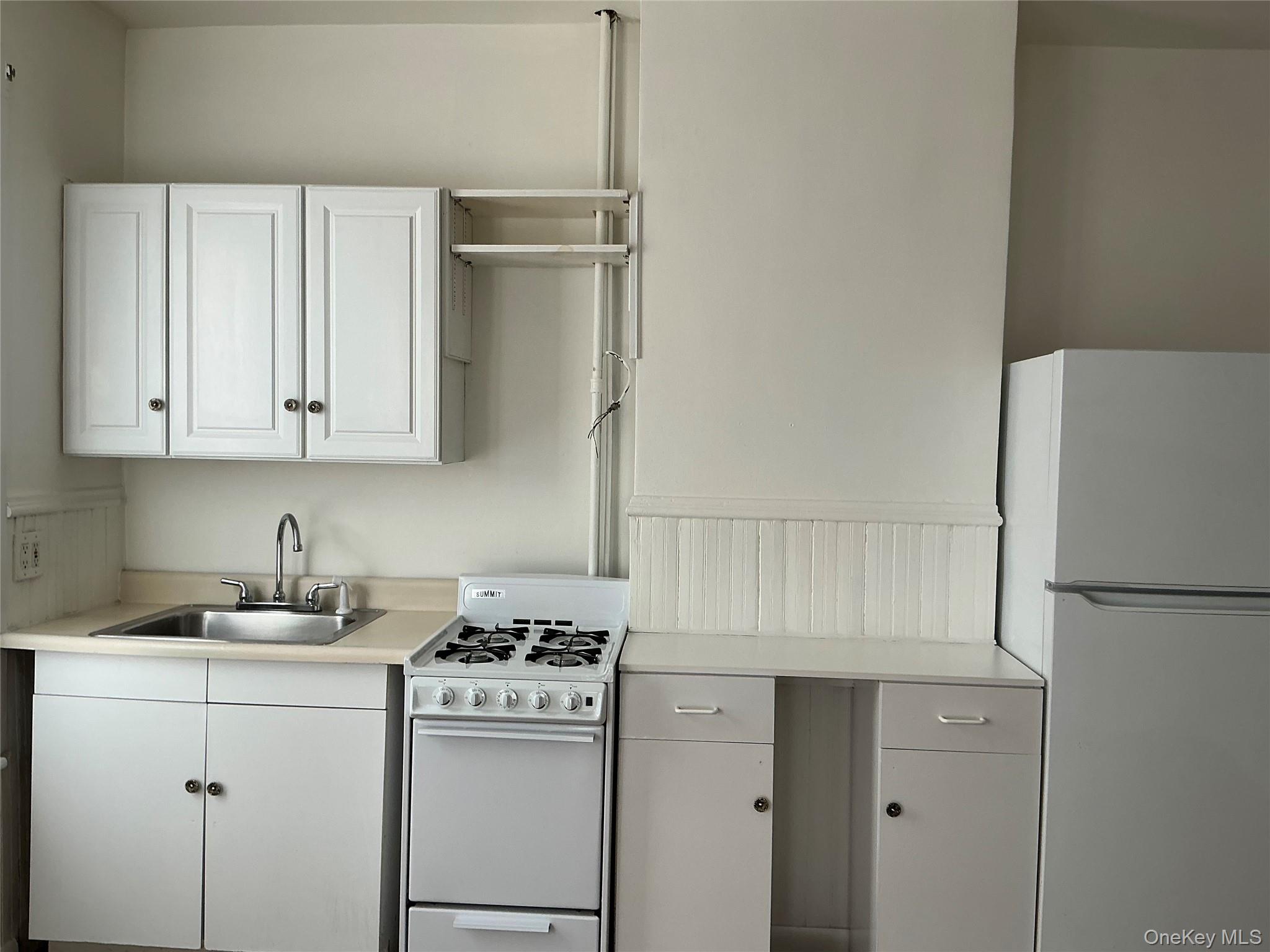 45 Fulton Avenue, Unit 2 Poughkeepsie, NY 12603 - Photo 6 of 15 Kitchen with white appliances, light countertops, and white cabinetry