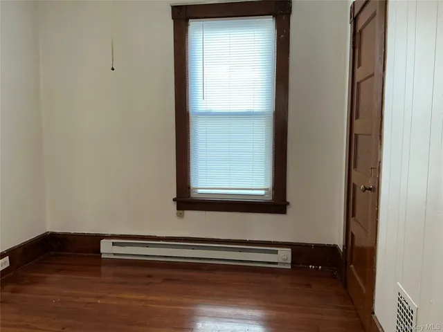 a view of small space with wooden floor and a window