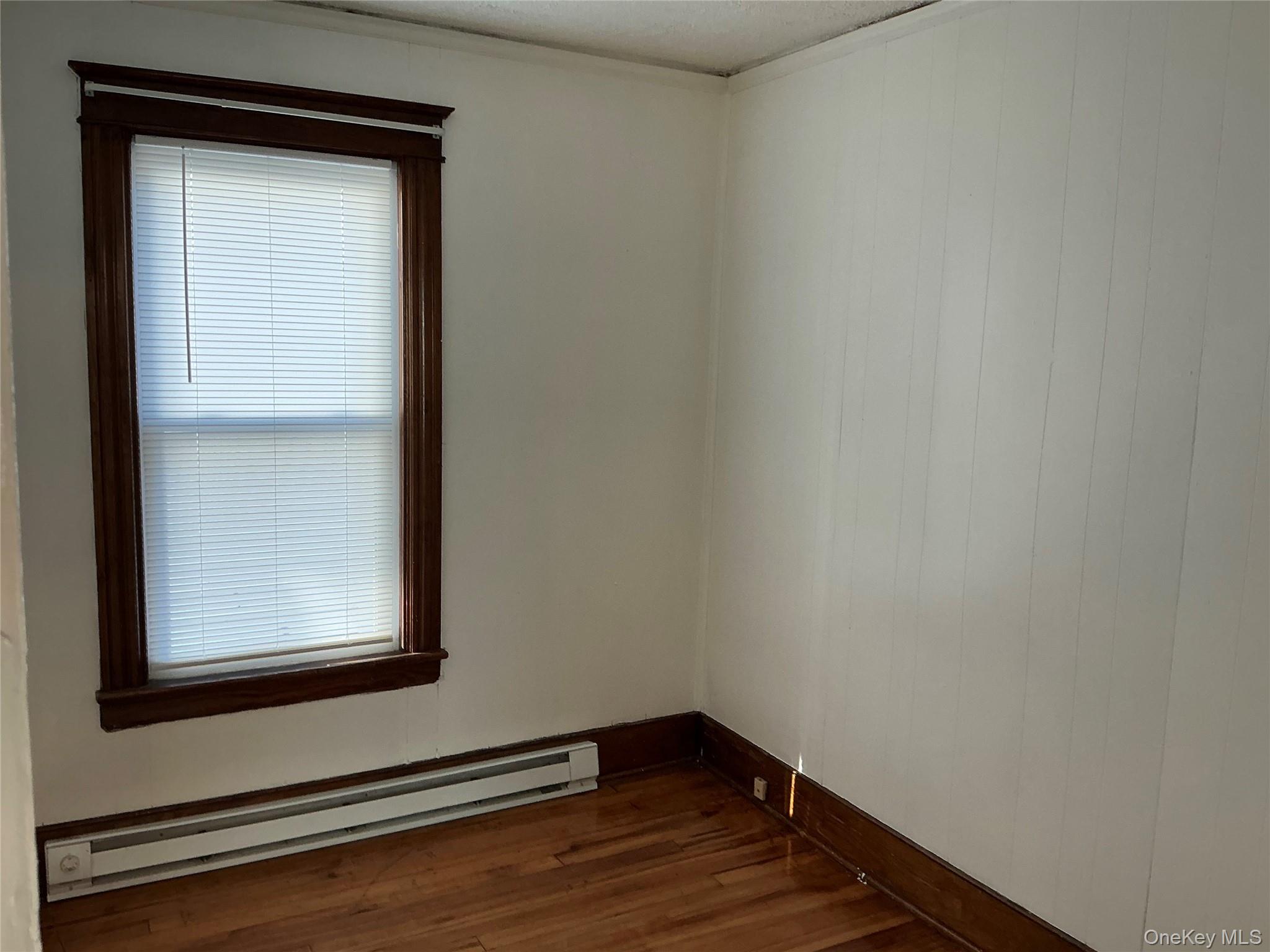 45 Fulton Avenue, Unit 2 Poughkeepsie, NY 12603 - Photo 9 of 15 Spare room with baseboard heating and dark wood-style flooring