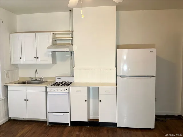 a kitchen with cabinets appliances and wooden floor