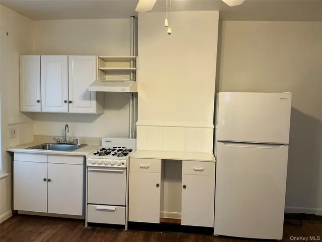 a white refrigerator freezer sitting inside of a kitchen