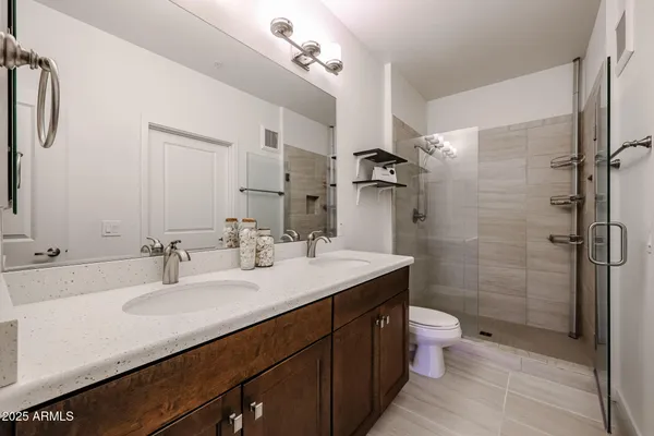 a bathroom with a double vanity sink toilet and shower