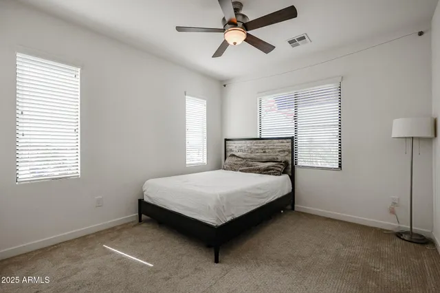 a bedroom with a bed lamp and a window